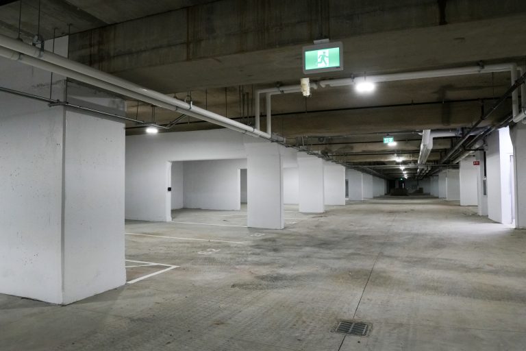 M&M Painting Contractors painting concrete walls in a parking garage.